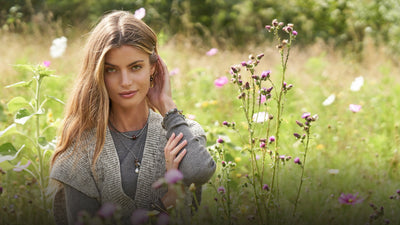 Woman in a summer flower field with Trollbeads necklaces, bracelets and earring