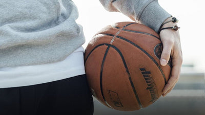 Man holding a basketball wearing Trollbeads bracelets